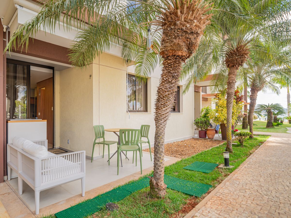 Varanda do flat com jardim e palmeiras